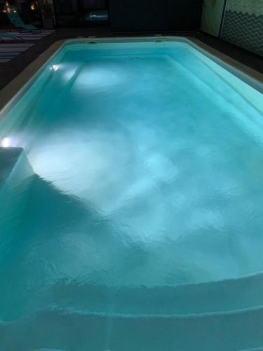 - une piscine avec des lumières bleues dans l'établissement La Metairie-du-Vauhariot - Lodge ou Chambre - Piscine Chauffée - Vue Mer et Mont Saint Michel - GR34 - Résidence Hôtelière, à Cancale
