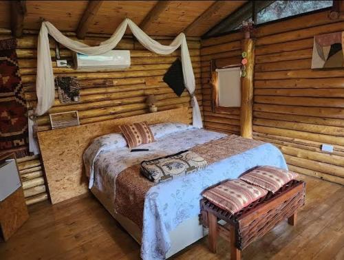 1 dormitorio con 1 cama en una cabaña de madera en Pualy Resort & Spa en Belén de Escobar