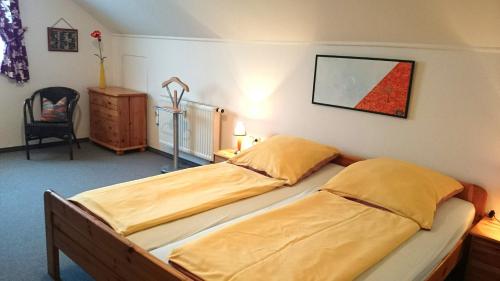 a bedroom with two beds and a chair at Haus Rottauenblick in Bad Birnbach