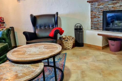 a leather chair and a table in a living room with a fireplace at Acogedora casa del siglo XIX in Bahabón