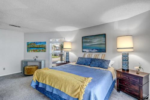 a bedroom with a blue bed and two lamps at Neptune's Nest in Neptune Beach