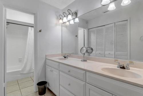 uma casa de banho branca com 2 lavatórios e um espelho em The Blue Turtle em Ponte Vedra Beach