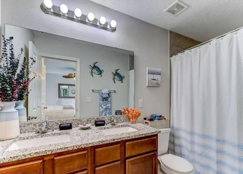 a bathroom with two sinks and a toilet and a mirror at The Elizabeth in Jacksonville