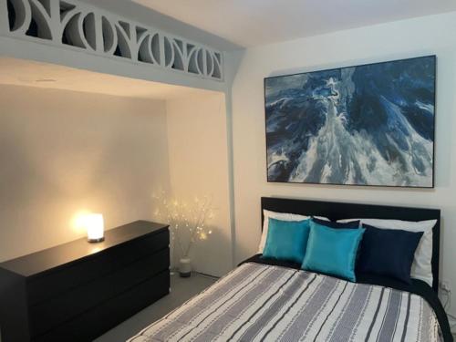 Casa del Sol -Unit B في بايامون: غرفة نوم مع سرير مع لوحة كبيرة على الحائط