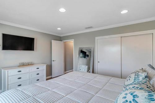 a bedroom with a bed and a tv on the wall at PVB Wellness Retreat in Ponte Vedra Beach