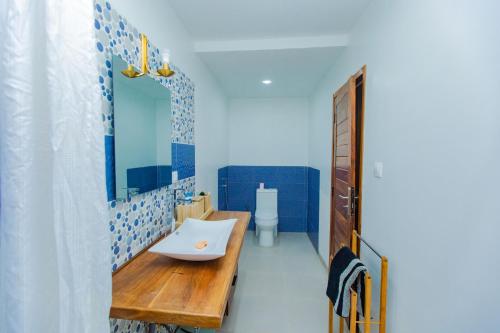 ein Bad mit einem Waschbecken und einem Spiegel in der Unterkunft Résidence Decamaret Warang in Ouoran