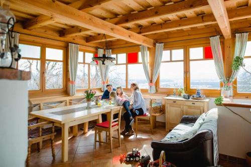eine Gruppe von Menschen, die an einem Tisch in einer Küche sitzen in der Unterkunft Ferienwohnung Stiegelbauer Zirbe in Gleinstätten