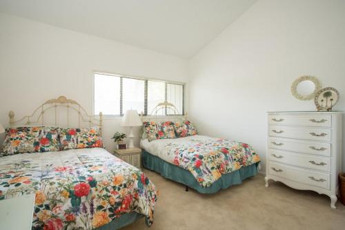 a bedroom with two beds and a dresser and a mirror at Shady Palms in Ponte Vedra Beach
