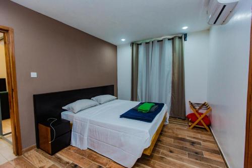 Un dormitorio con una cama con una manta azul. en Résidence Decamaret Warang en Ouoran