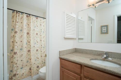 a bathroom with a sink and a shower curtain at Shady Palms in Ponte Vedra Beach