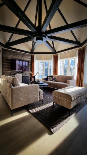 a large living room with couches and a ceiling at Sølvgarden Hotel in Rysstad