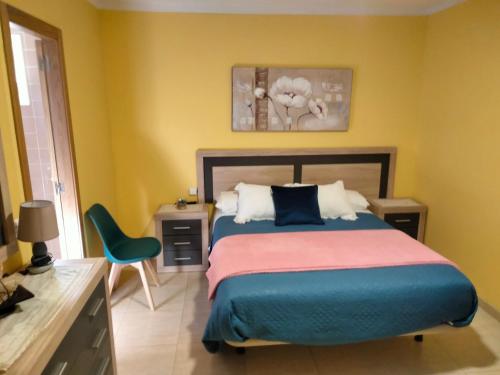 a bedroom with a bed and a desk and a chair at Hostal Nuevo Alonso in Bembribe