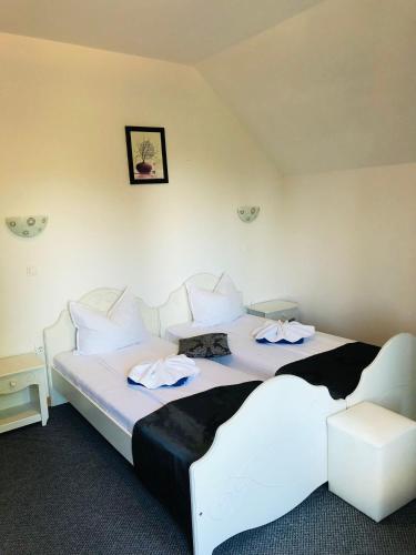 a bedroom with a large bed with white sheets and pillows at Pensiunea Contesa in Sovata