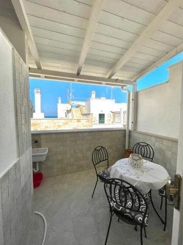 a patio with a table and chairs on a balcony at Affittacamere Luluc in Polignano a Mare