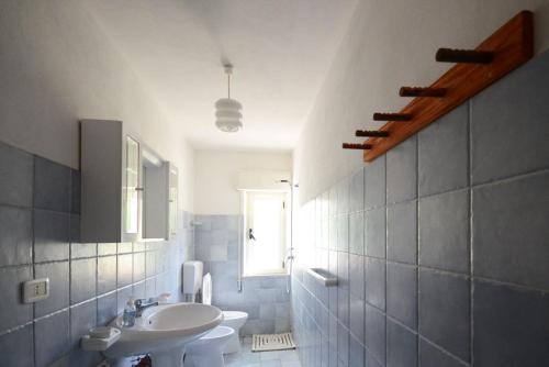 a bathroom with a sink and a toilet and a window at Appartamenti Salusai in Trinità d'Agultu e Vignola