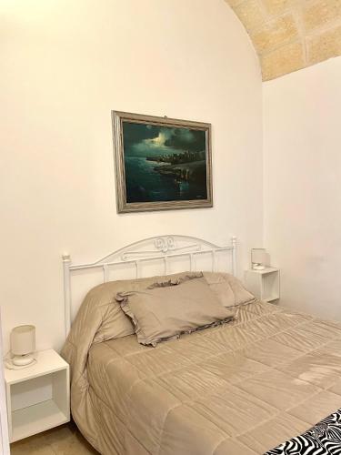 a bedroom with a bed and a painting on the wall at Affittacamere Luluc in Polignano a Mare