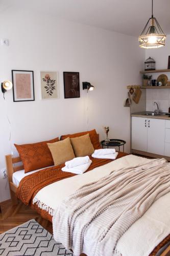 ein Schlafzimmer mit einem großen Bett mit einer Decke in der Unterkunft Bohome studio sa terasom - FREE PARKING in Vranje