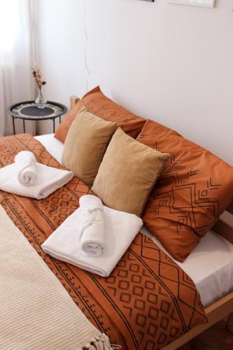 un letto con due asciugamani e cuscini sopra di Bohome studio sa terasom - FREE PARKING a Vranje
