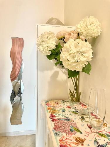 a table with a vase of flowers on it at Affittacamere Luluc in Polignano a Mare
