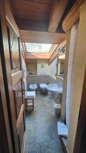 a bathroom with two toilets and a sink at Hotel Lo Campagnar in Courmayeur