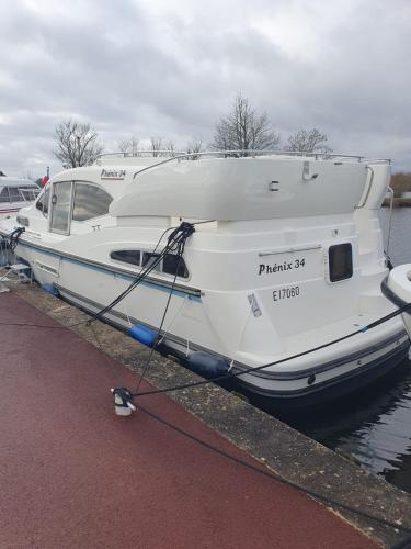 un bateau blanc est amarré dans l'eau dans l'établissement Magnifique bateau au coeur du Nivernais à l'étang de BAYE, à Bazolles