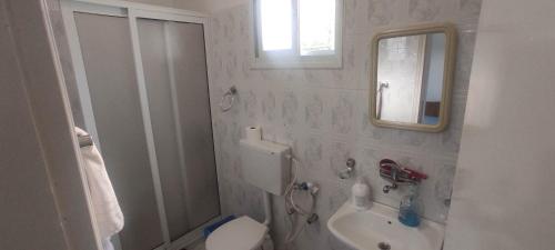 uma casa de banho com um WC, um lavatório e um espelho. em Reema's House em Bayt Sāḩūr