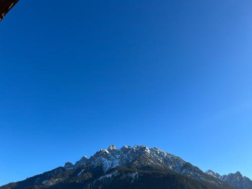 a mountain top with a blue sky in the background at Guesthouse Rosengarten in Dobbiaco