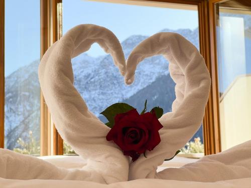 a valentines heart made out of towels with a rose at Guesthouse Rosengarten in Dobbiaco