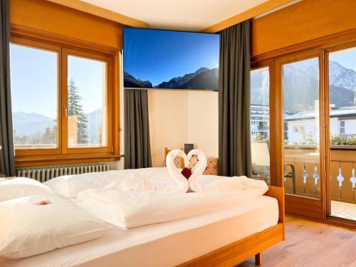 a bedroom with a bed and a large window at Guesthouse Rosengarten in Dobbiaco