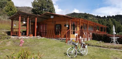 una cabaña de madera con una bicicleta estacionada frente a ella en Balcones del Lago de Tota, en Sogamoso