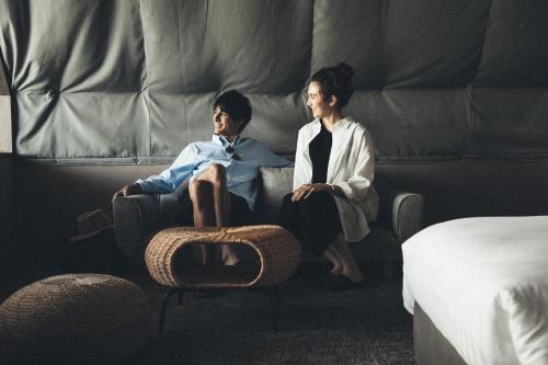 Tamano的住宿－SETONITE，两个男人坐在卧室的沙发上
