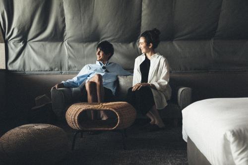 玉野市にあるSETONITEの二人の男が寝室のソファに座っている