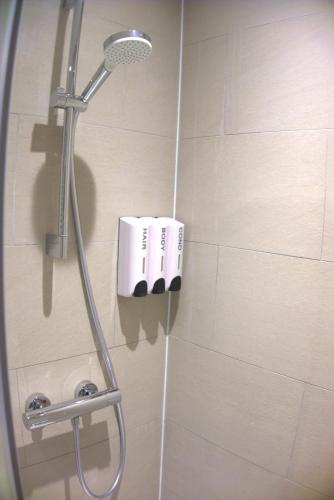 a shower with a shower head in a bathroom at Abbey Point Hotel in London