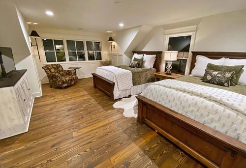 ein großes Schlafzimmer mit 2 Betten und einem Stuhl in der Unterkunft The Nest at Cardinal Hill Dahlonega in Dahlonega
