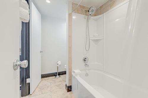 a white bathroom with a tub and a shower at Paradise Dream Vacations #1 in Indialantic