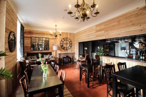 a restaurant with wooden walls and tables and a fireplace at The Elan Valley Hotel in Rhayader