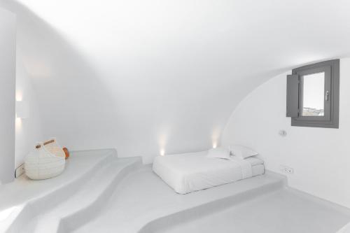 a white room with a bed and a mirror at Philosophia Luxury Villa in Megalokhori