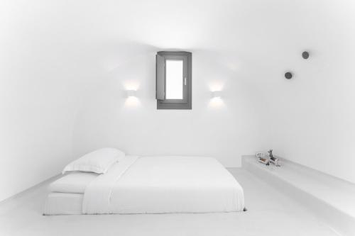 a white bedroom with a bed and a mirror at Philosophia Luxury Villa in Megalokhori