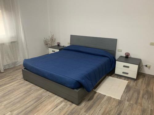 um quarto com uma cama azul e duas mesas de cabeceira em Al Capitello em Mira