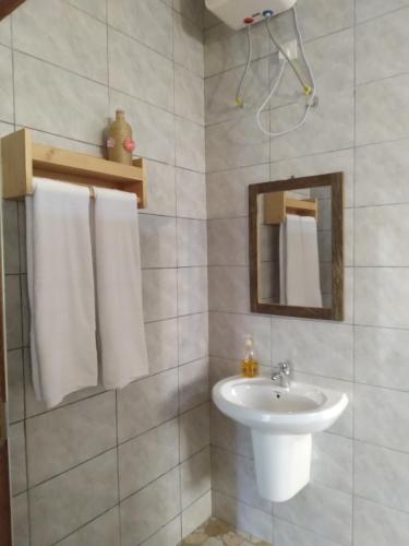 Baño blanco con lavabo y espejo en Materuni Homes en Moshi
