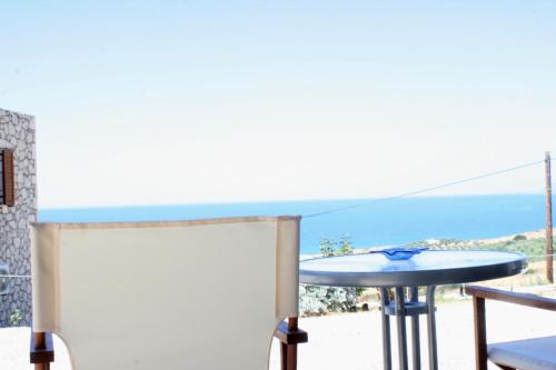a balcony with a table and a view of the ocean at Kapsali House in Keratokampos