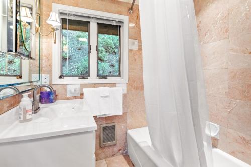 a bathroom with a sink and a shower curtain at Shadowood Serenity in Waynesville