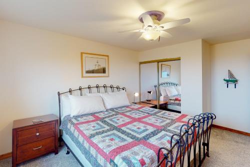 a bedroom with a bed and a ceiling fan at Cape Satisfaction in Ilwaco