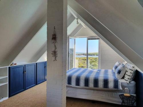 - une chambre avec un lit doté de placards bleus et une fenêtre dans l'établissement Sunbird House, à Grotto Bay