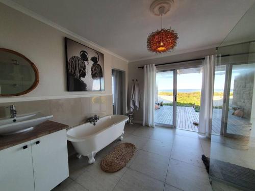La salle de bains est pourvue d'une baignoire, d'un lavabo et d'un miroir. dans l'établissement Sunbird House, à Grotto Bay