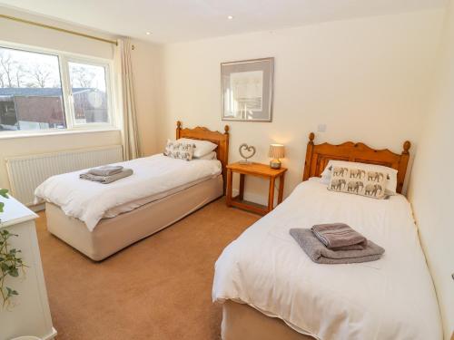 a bedroom with two beds and a window at Church View Cottage in Doncaster