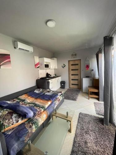 ein Wohnzimmer mit einem Bett und eine Küche in der Unterkunft Vivien vendégház in Zamárdi