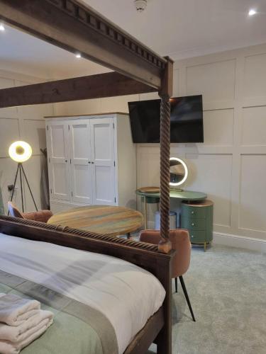 a bedroom with a bed and a table and a television at The Resolution Hotel in Whitby