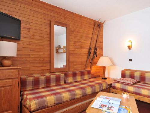 une chambre d'hôtel avec un canapé et un miroir dans l'établissement Appart 2 pièces 5 pers. au cœur de la station avec balcon et piscine - FR-1-181-1030, à Plagne Bellecôte