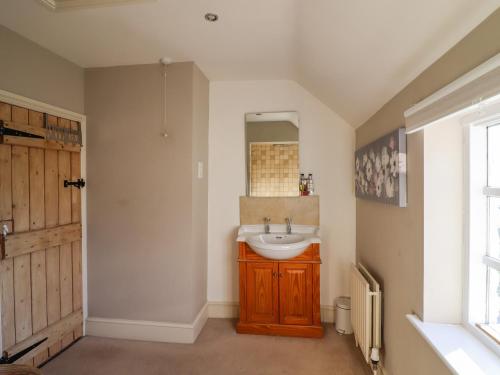 ein Bad mit einem Waschbecken und einem Spiegel in der Unterkunft Garden Cottage in Doncaster